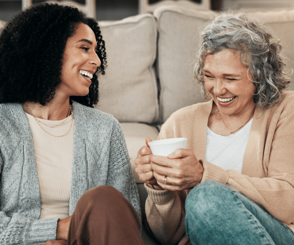 Mother and daughter sitting on the floor drinking coffee