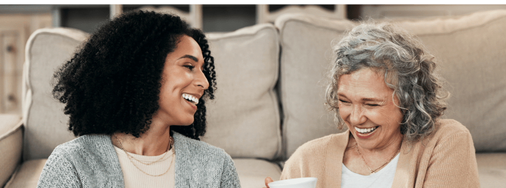 Mother and daughter sitting on the floor drinking coffee